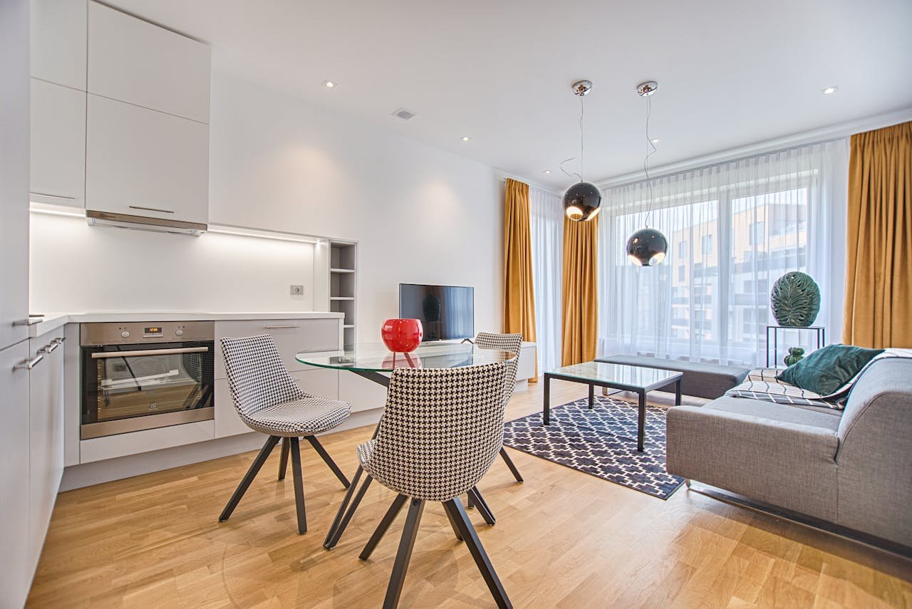 our-story Elegant Scandinavian-style living room and kitchen featuring modern furniture and decor.